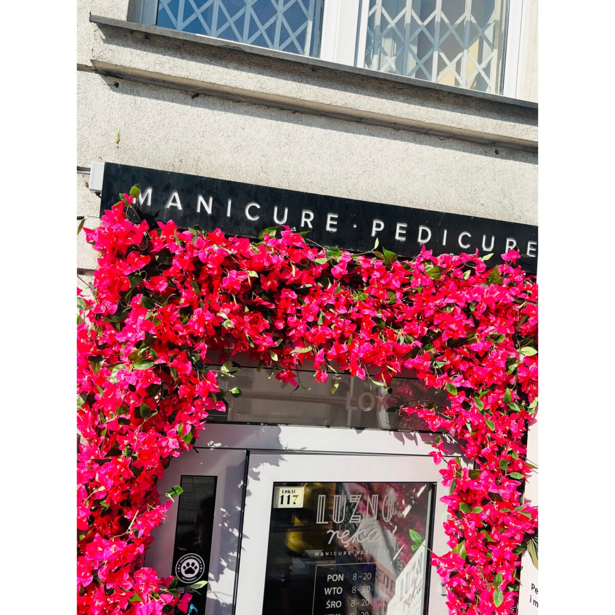 Instalacja fuksjowa z kwiatów bugenwilla w kształcie litery „u”