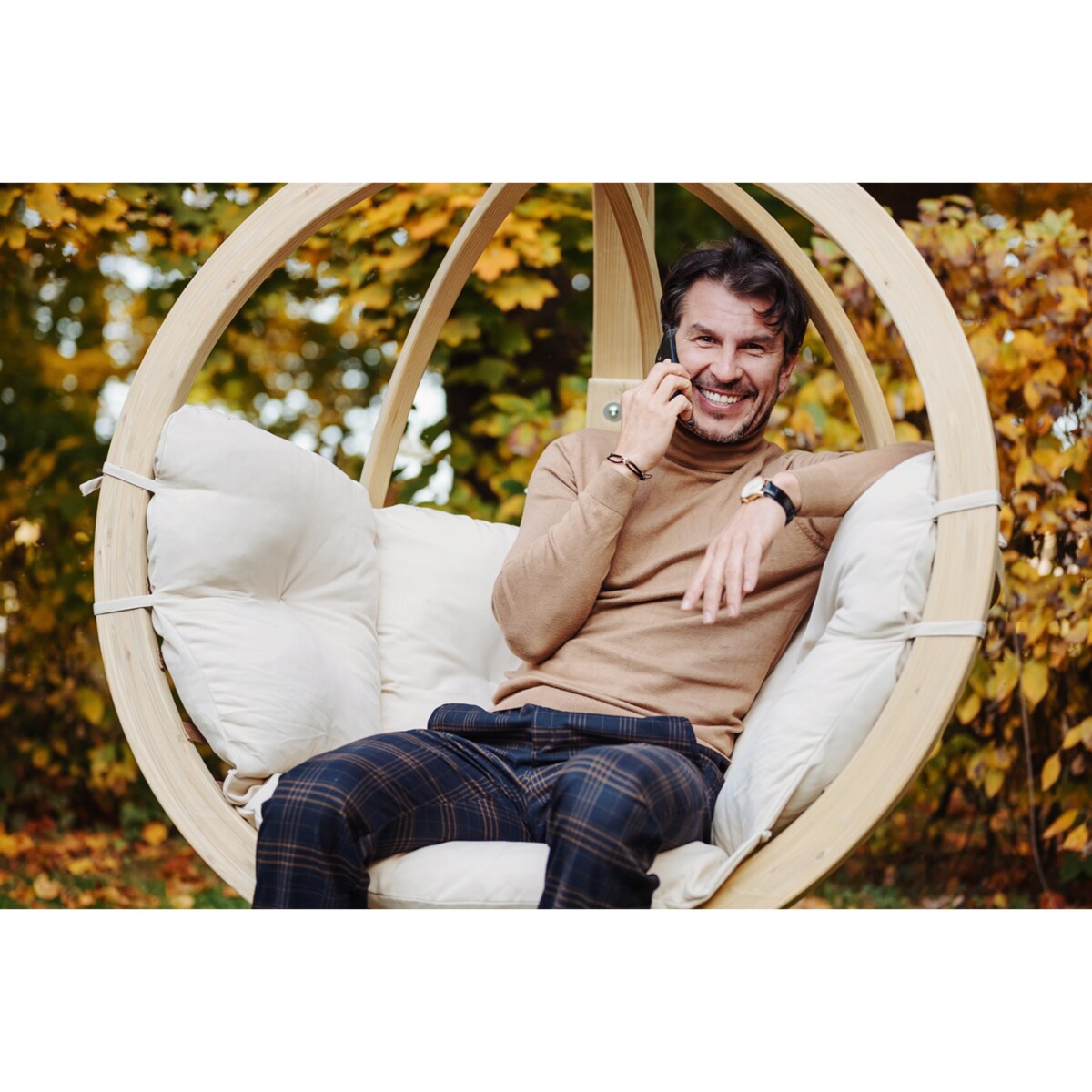 KONSIMO HIGLO Kremowy drewniany fotel wiszący boho w ogrodzie