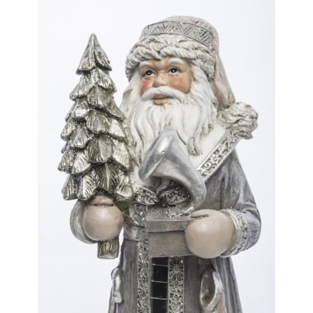 Mikołaj w płaszczu obszytym białym futrem ze srebrną choinką i brązową skarpetą na prezenty 22,5x8,5x7 cm